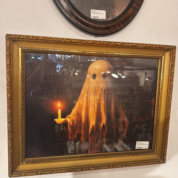 Ghost holding candle in gold frame