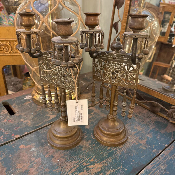 Pair of early 20th-century heavy brass candleholders with filigree floral panels and hanging pendants. Exceptional patina and craftsmanship-sculptural even unlit.