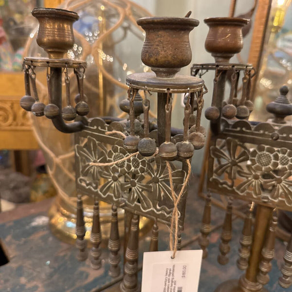 Pair of early 20th-century heavy brass candleholders with filigree floral panels and hanging pendants. Exceptional patina and craftsmanship-sculptural even unlit.